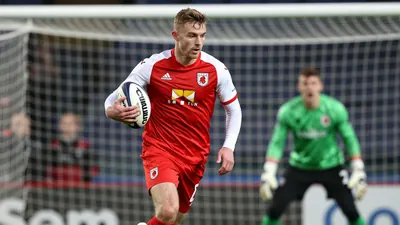 A photorealistic image of an anonymous ST Johnstone player in a red jersey with white sleeves, running with the ball...