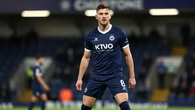 A photorealistic image of an anonymous ST Johnstone player in their navy blue home kit, with a white collar and navy blue...